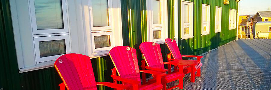 Four red chairs on a deck.