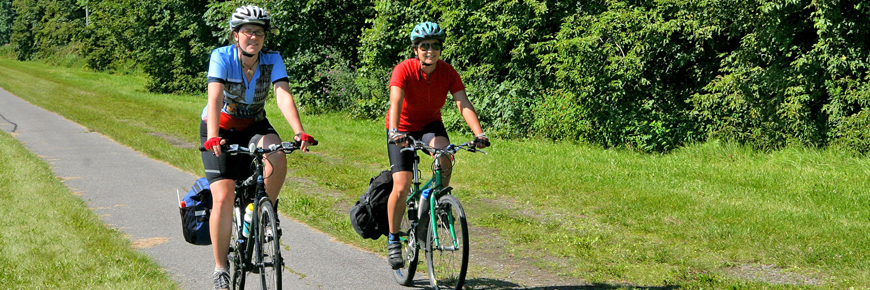 Two people cycling down a trail