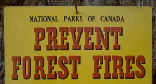 Un vieux panneau de Parcs Canada qui dit Prévenir les incendies de forêt