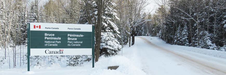 A sign leading to the park covered in snow. 