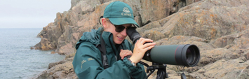 A Parks Canada employee looking through a scope.
