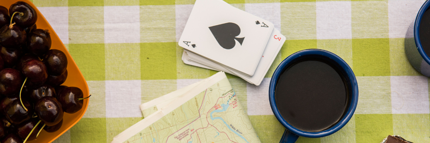 A coffee cup, a playing card, some cherries, and a map.