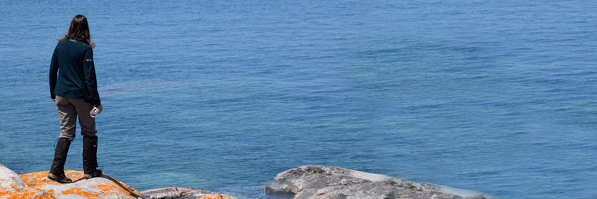  Une personne debout sur un rivage rocheux.