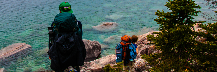 Two hikers on the shore of Lake Superior.