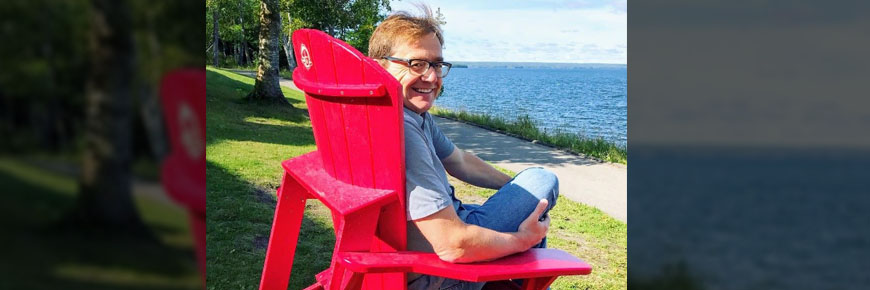 Le ministre Wilkinson assis dans une chaise rouge de Parcs Canada