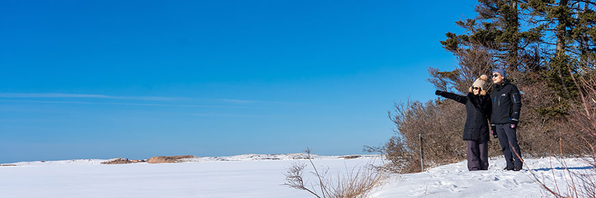 Two hikers at a lookout point on a sunny winter day on the Homestead Trail in Cavendish, Prince Edward Island National Park. 