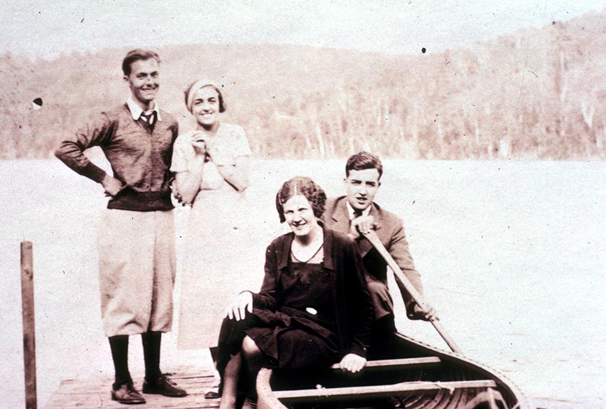 Two couples lavishly dressed on a dock.