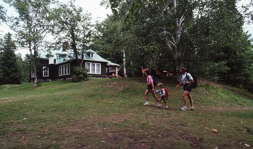 Une famille marche devant le gîte Wabenaki.