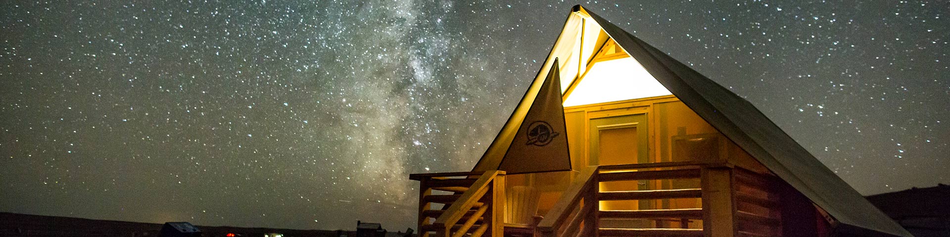  Un abri oTENTik de Parcs Canada entouré de la Voie lactée dans la réserve de ciel étoilé, au parc national des Prairies.