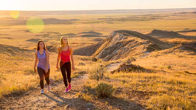 De jeunes adultes en randonnée sur le sentier de Butte-70-Mile du bloc Ouest, dans le parc national des Prairies