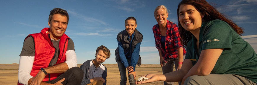 Grasslands National Park interpreter shows family educational props at a prairie dog colony.