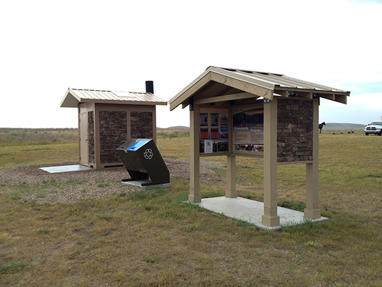Informational kiosk, waste and recycling receptacle and vault toilet at the Belza day use site.
