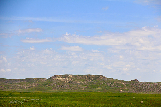 La butte 70-Mile, l’un des sommets les plus élevés du parc, au loin avec un ciel bleu nuageux en arrière-plan. 