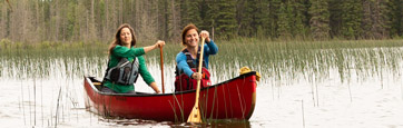 Two canoeists paddling on a lake. 