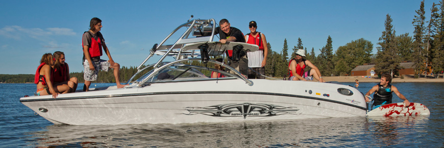 A group of young adults pose for a picture while relaxing on a sporty motorboat. 