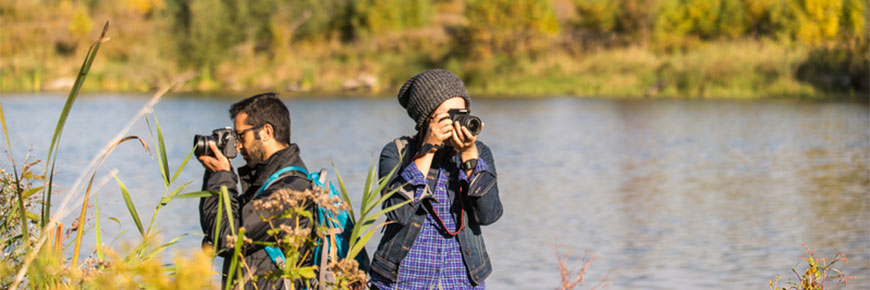 Deux photographes prennent des photos de la faune près d’un lac.