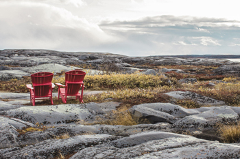 Les chaises rouges de Parcs Canada surplombant les terrains de la batterie du cap Merry.