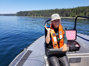A Parks Canada employee using a hydrophone from a boat