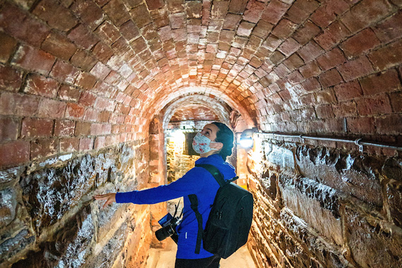 A visitor exploring brick tunnels.