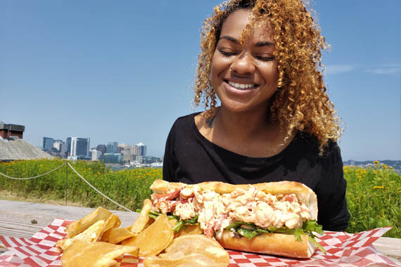 A visitor enjoying a lobster roll picnic.