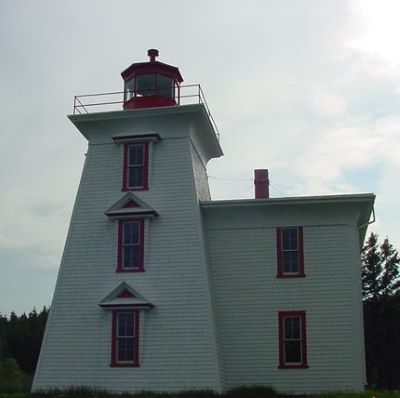 Vue générale du phare et de sa résidence, qui montre la volumétrie, soit une tour carrée et évasée, de hauteur moyenne, avec une résidence contiguë de deux étages de hauteur, terminée par un toit plat. (© Fisheries and Oceans Canada | Pêches et Océans Canada, 2024)