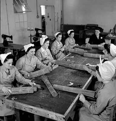 Des femmes mettent de la cordite en paquets pour un obus de la marine à la société Defence Industries Ltd. de Montréal (Québec). Juin 1944 © Harry Rowed / Office national du film du Canada. Photothèque / Bibliothèque et Archives Canada | National Film Board of Canada. Photothèque / Library and Archives Canada / PA-116926