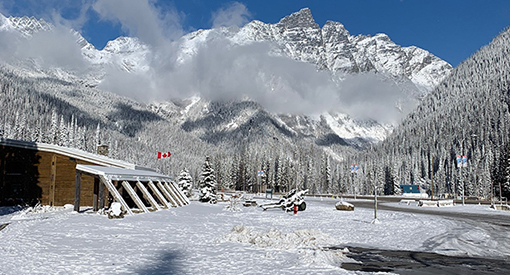 Visitor centre covered in snow with mountains in the background